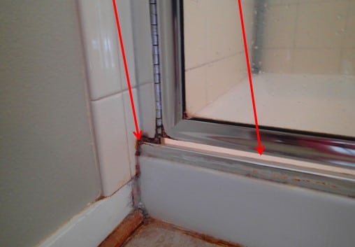 Failed grout and missing door seal.
